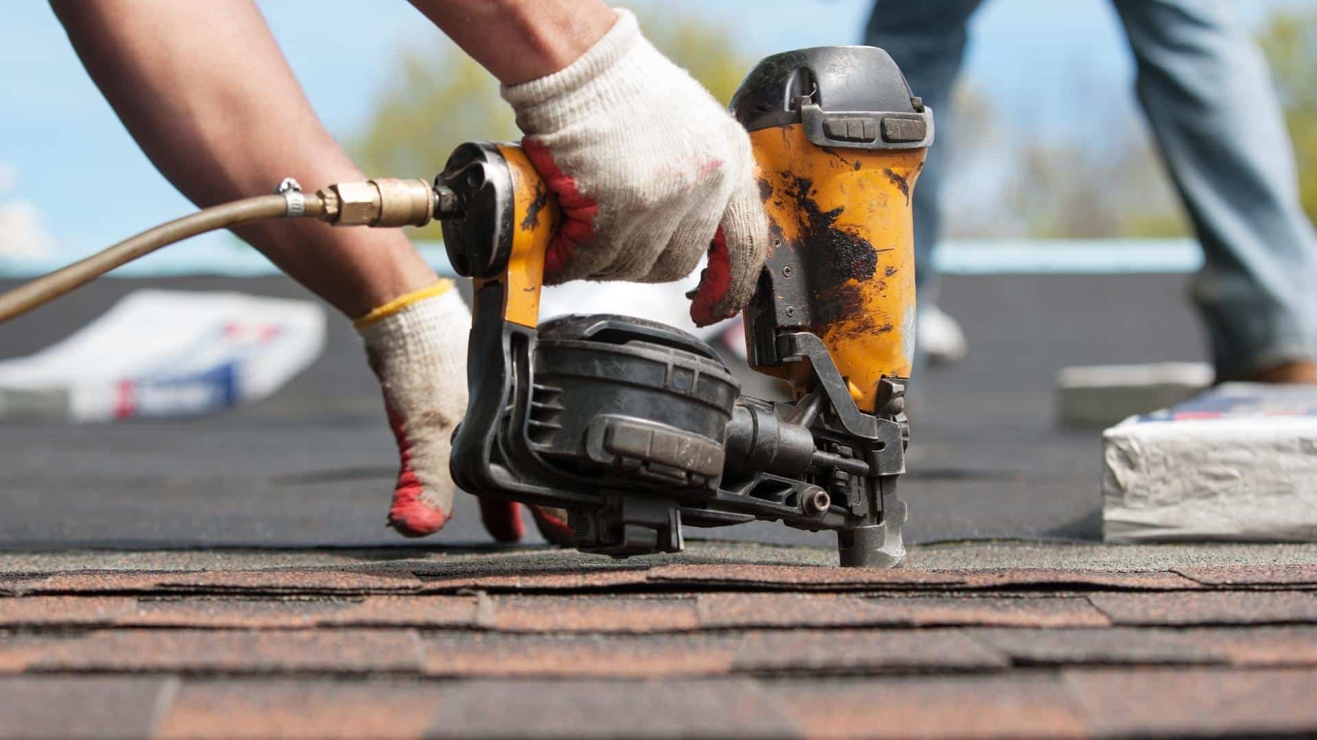 contractor-hands-close-up-with-drill-installing-asphalt-shingles-at-roof-tyler-tx